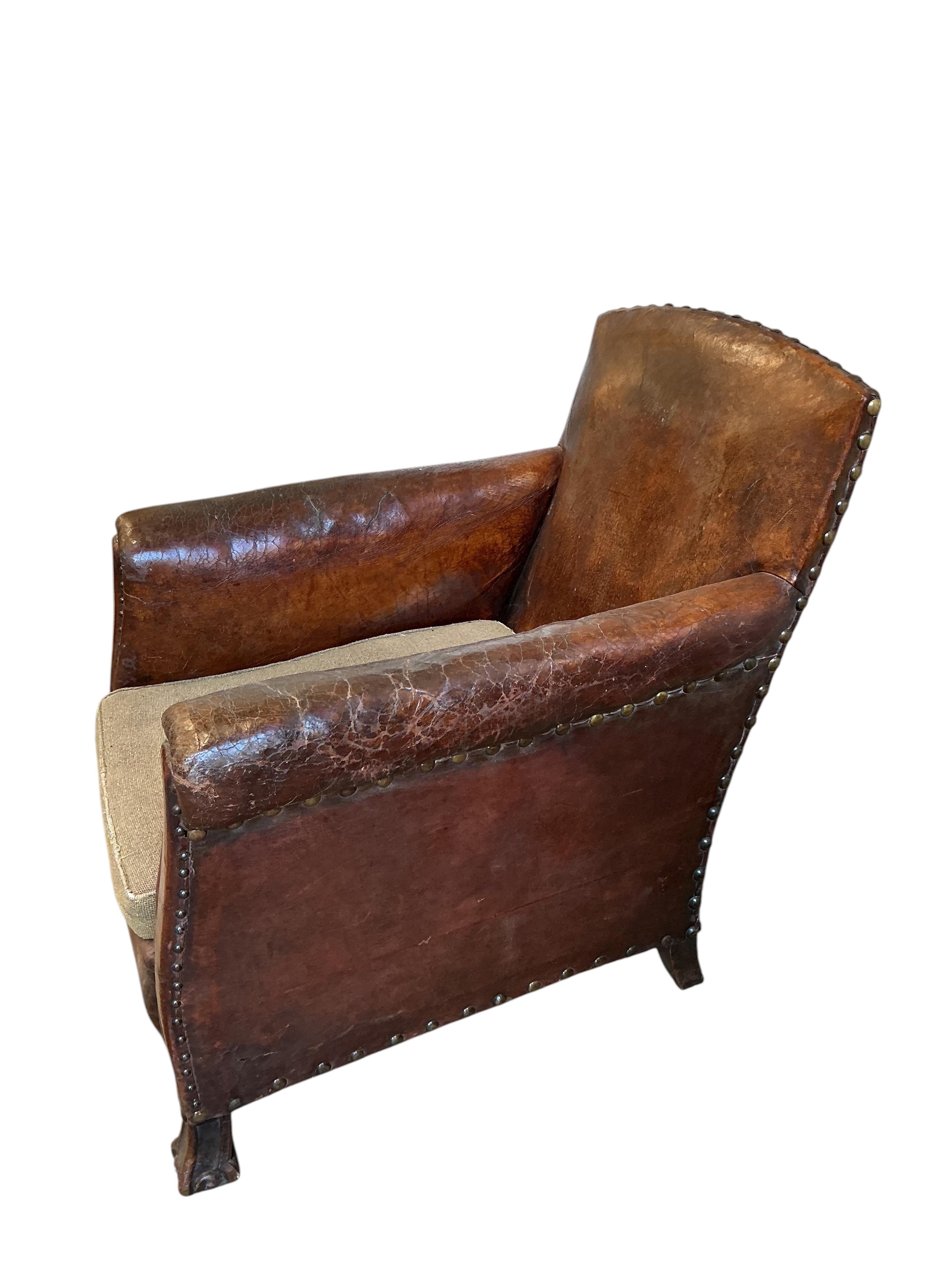 A near pair of early 20th century studded brown leather club chairs, width 79cm, depth 86cm, height 89cm